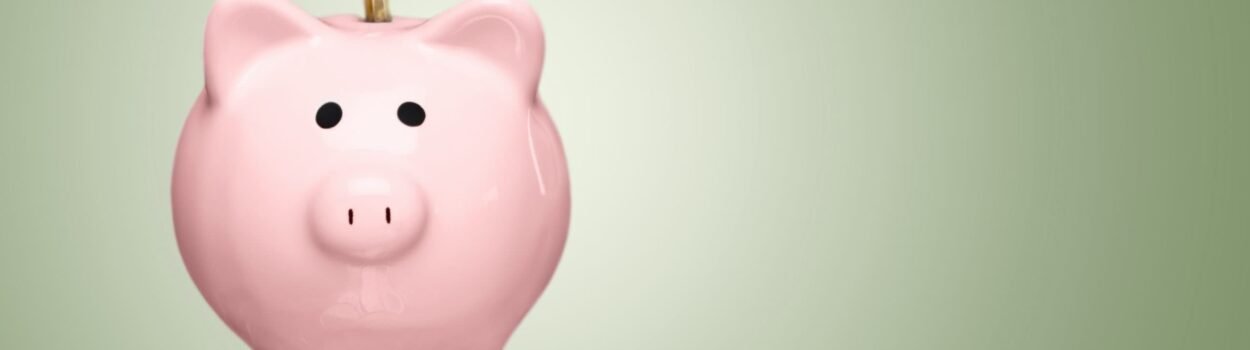 Tirelire cochon rose posée sur une pile de pièces de monnaie illustrant la liquidité financière.