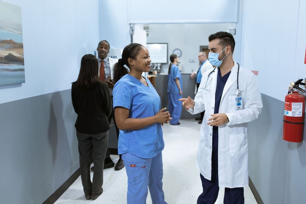 Professionnels de santé discutant dans un couloir d'hôpital Professionnels de santé discutant dans un couloir d'hôpital