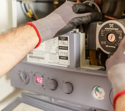 Technicien chauffagiste réglant les instruments d'une chaudière lors d'une intervention de maintenance à Toulouse