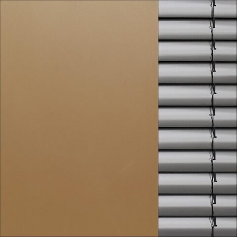Un mur beige à gauche et des volets métalliques horizontaux à droite