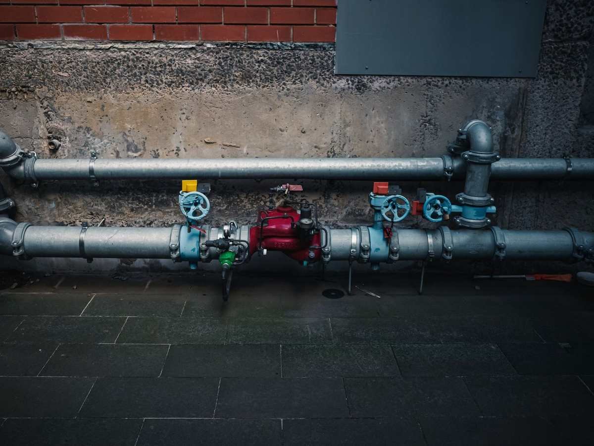 Industrial pipes with valves and gauges installed on a concrete wall
