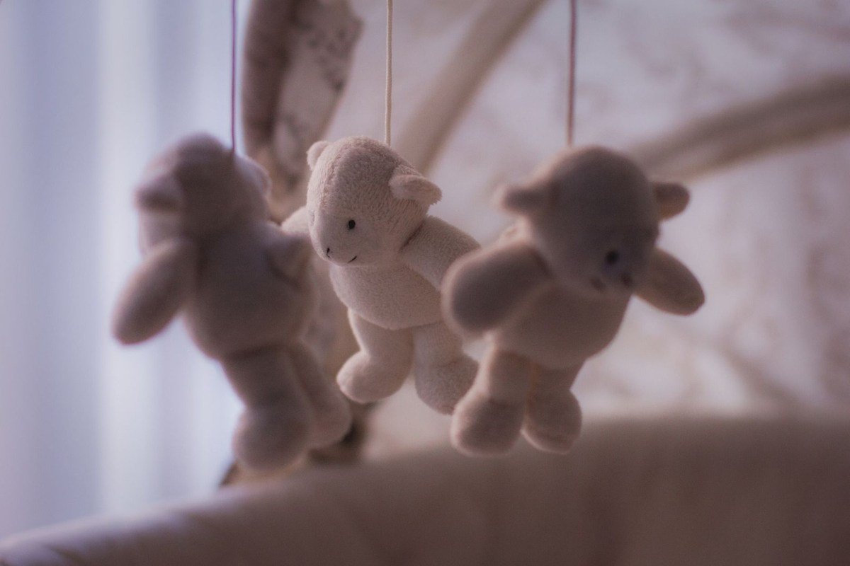Trois peluches en berceuse, deux lapins et un ours Trois peluches en berceuse, deux lapins et un ours