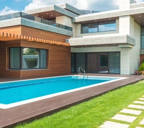 Piscine coque rectangulaire bleue installée dans le jardin d'une maison moderne à Bordeaux