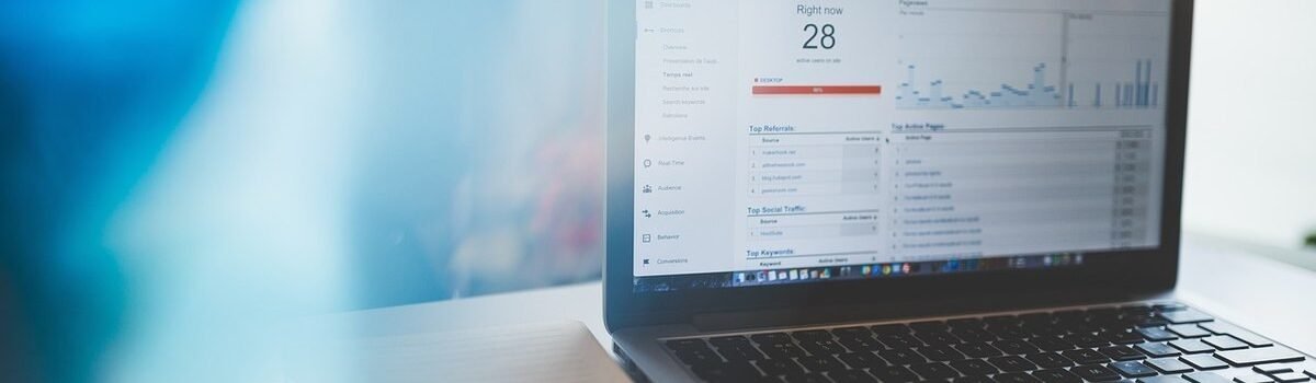 Laptop montrant graphique avec 28, stylo et cahier sur table