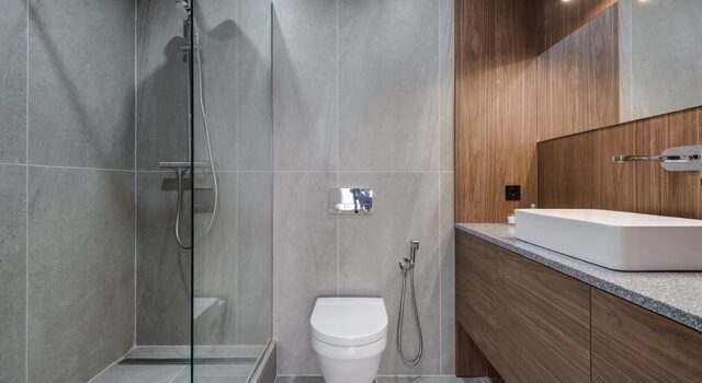 Salle de bain moderne avec douche à l'italienne et finitions continues, espace type pour une application de béton ciré en zone humide