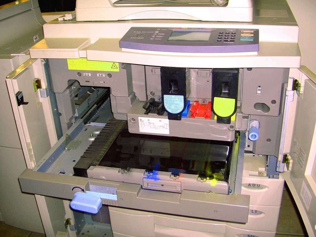 Photocopieur professionnel avec plateau papier ouvert et cartouches d'encre colorées installées