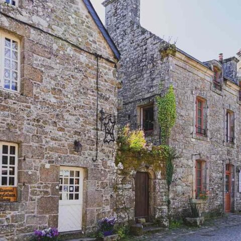 Anciennes maisons en pierre le long d'une rue pavée tranquille
