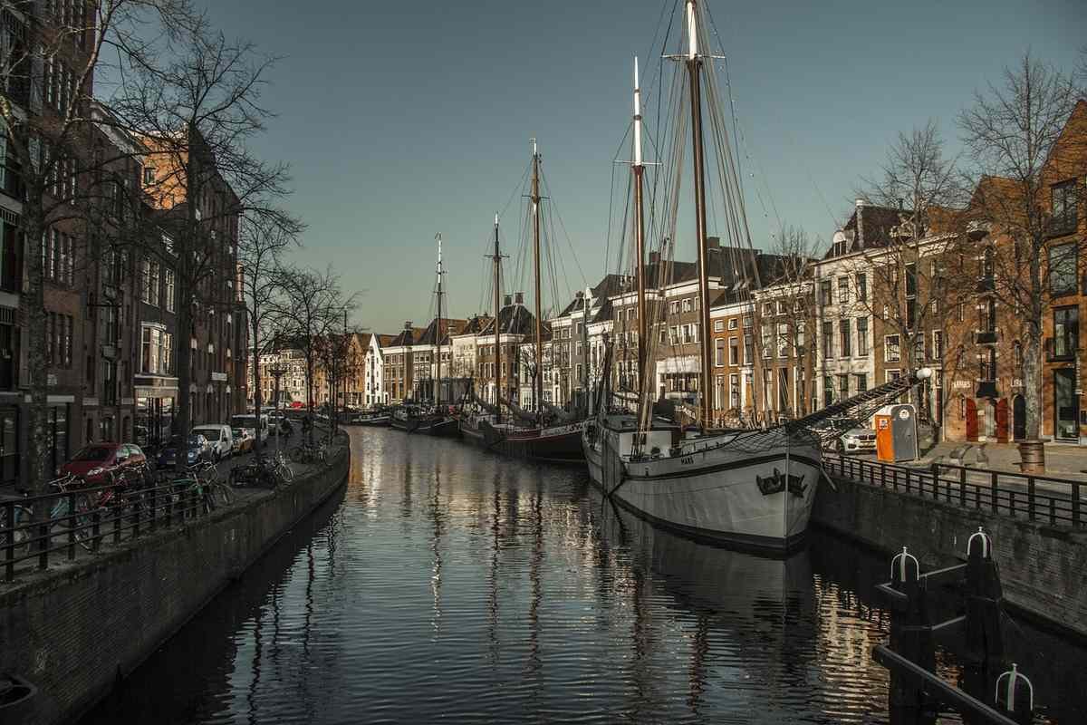 Un canal bordé de bateaux à voile et de maisons en briques